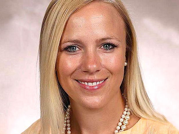 Alt text: Professional portrait of a smiling woman with long blonde hair and a pearl necklace.