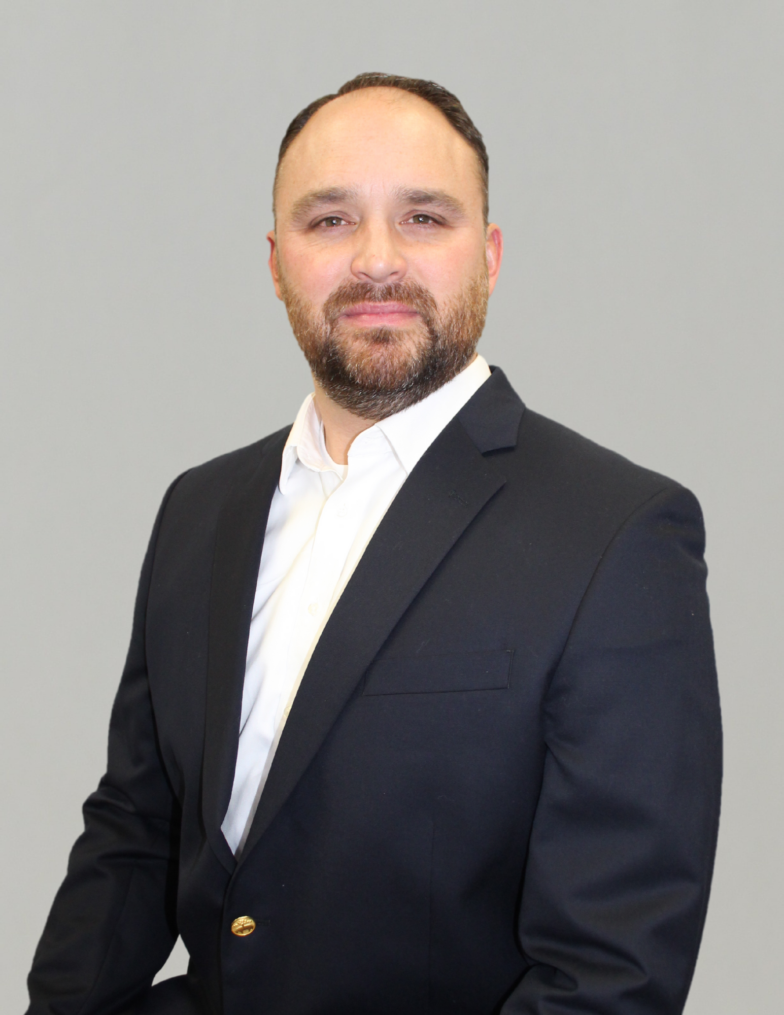Professional man in a suit against a plain background.