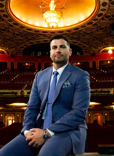 Senior VP Stefan Petrella leads arts risk solutions, seated in a theater, showcasing leadership and industry expertise.