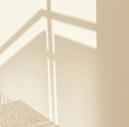 Sunlight casting geometric shadows on a beige wall, symbolizing innovative captive insurance strategies.