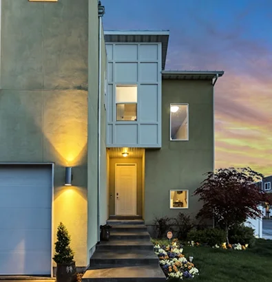 Modern home illuminated at dusk, highlighting the importance of property insurance for protection and security.
