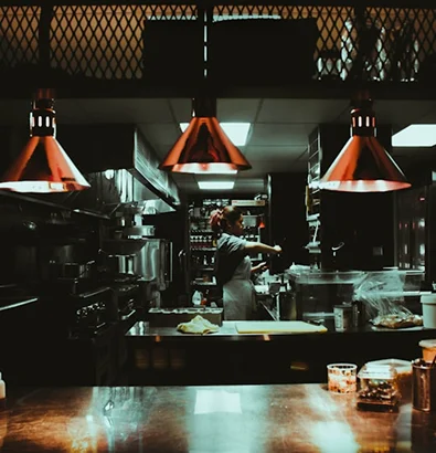Chef working in a dimly lit kitchen, highlighting the need for reliable insurance in hospitality businesses.