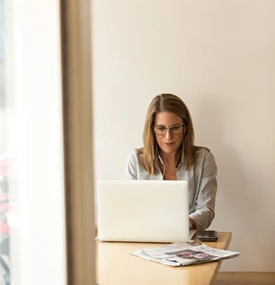 Financial professional working at laptop, focused on insurance solutions for financial institutions.