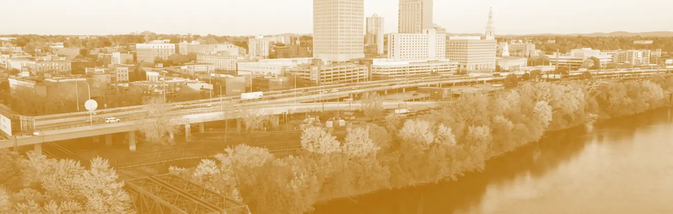 Massachusetts city skyline with river, highlighting business insurance service location.
